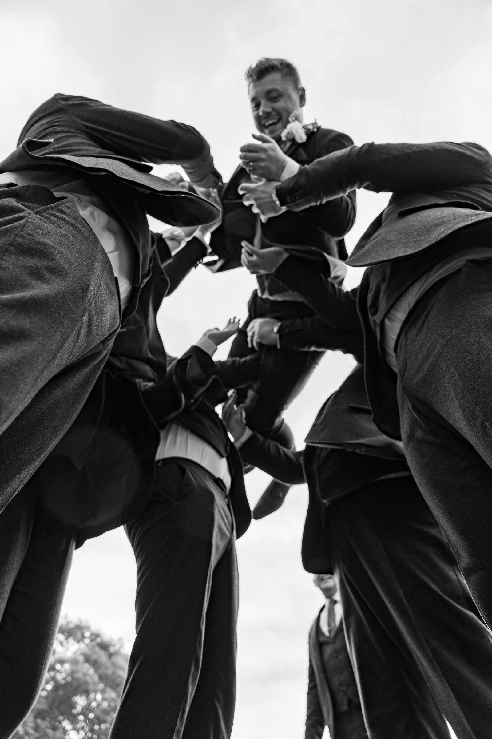 A groom being thrown into the air by his groomsmen